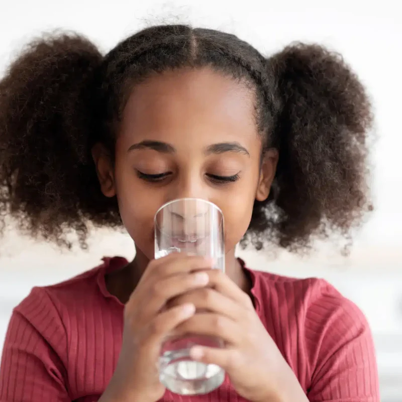 young-girl-drinking-water-in-bright-indoor-setting-2026-03-24-14-13-26-utc